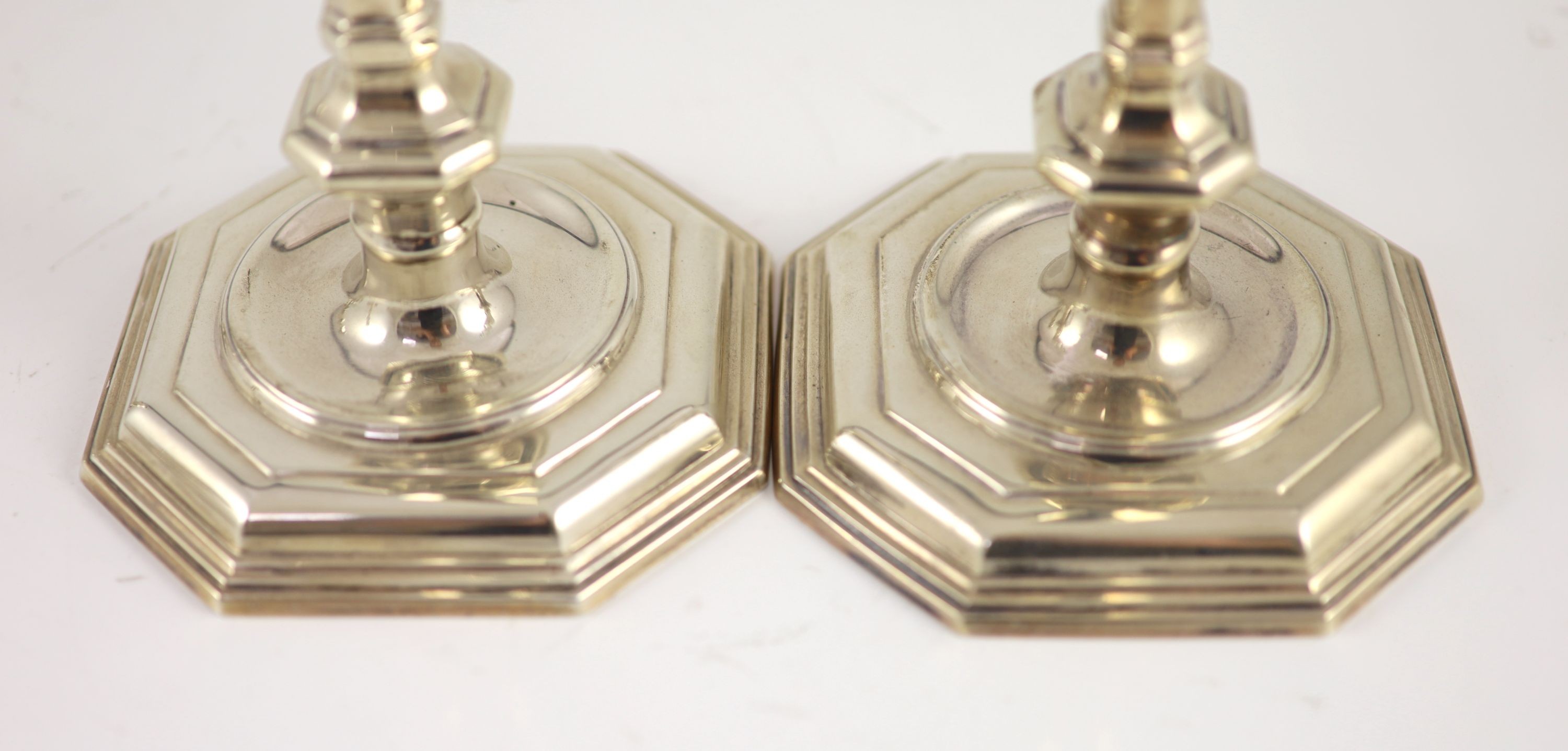 A set of four early 18th century design cast silver candlesticks